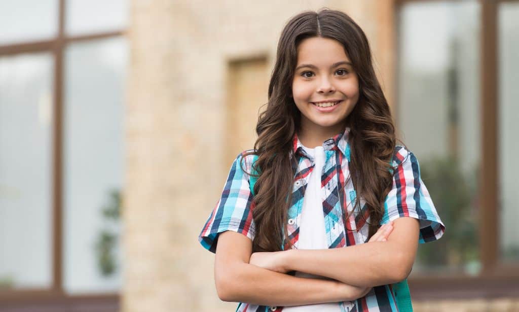 A girl smiling with arms folded across her chest