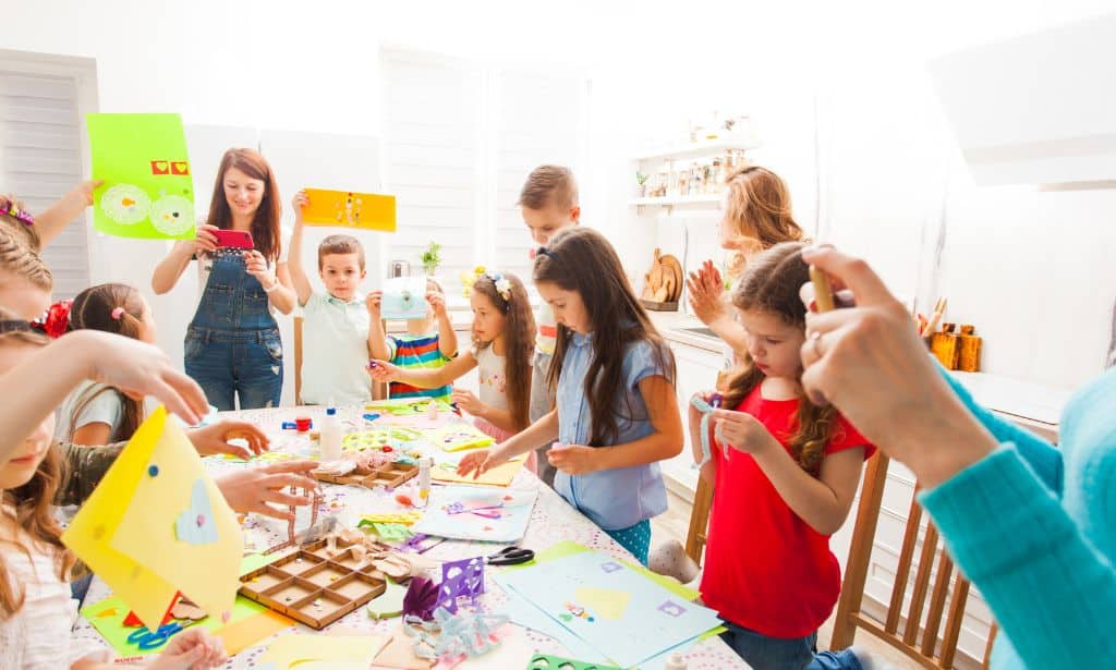 Kids busy creating items with paper and colors