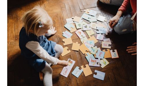 A boy and girl solving a floor puzzle