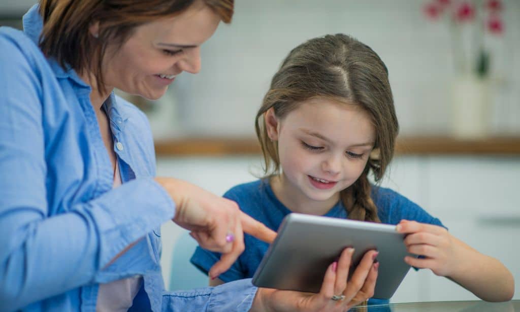 A mom showing a girl an image on a tablet