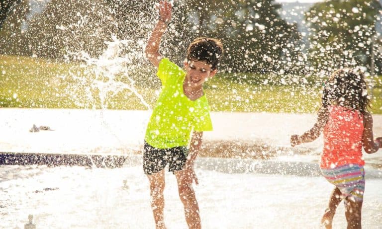 A boy and girl playing with water